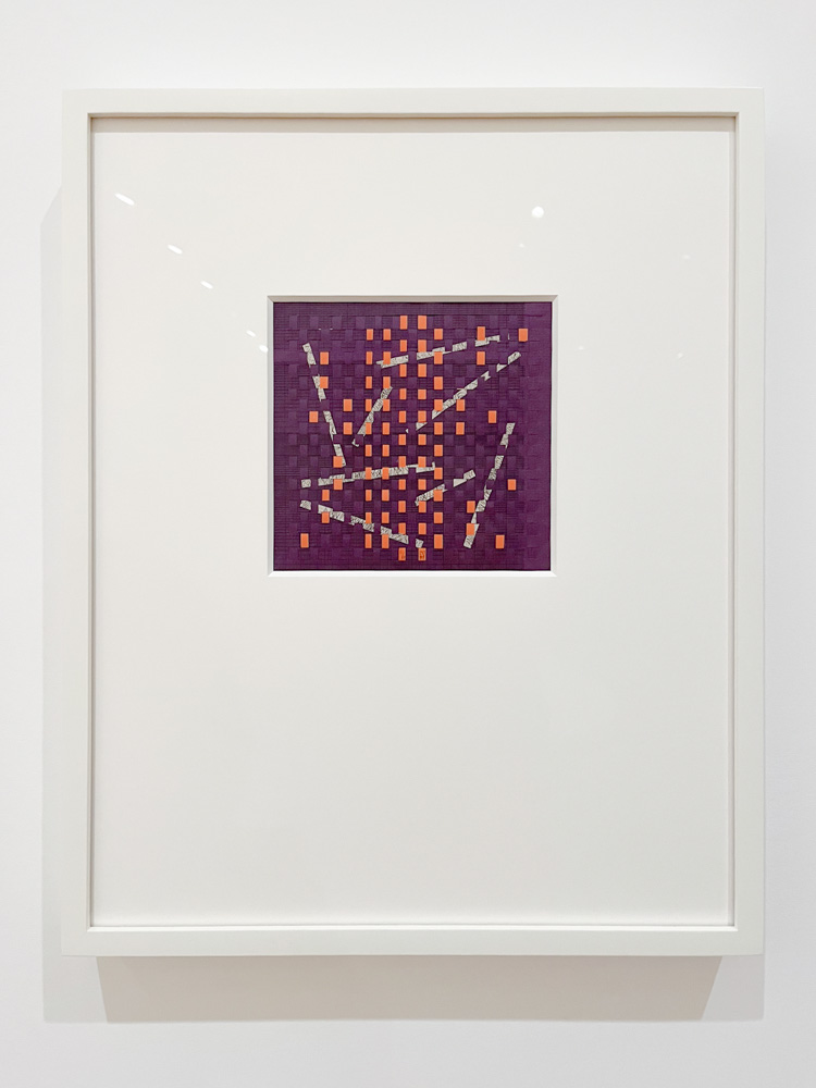 A weaving mad of thin strips of purble, orange and white paper.